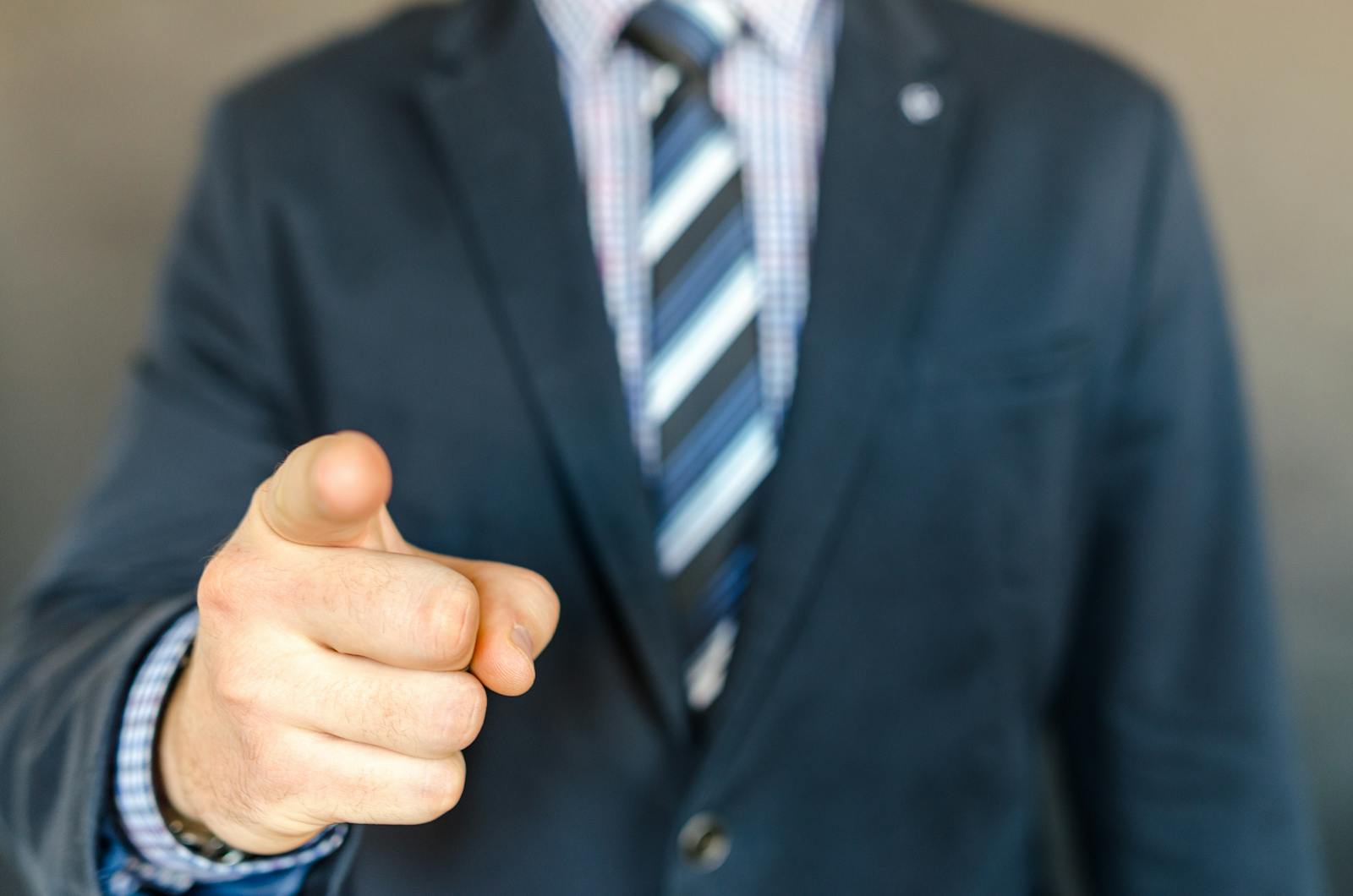 A businessman in a dark suit points forward, emphasizing focus and professionalism.